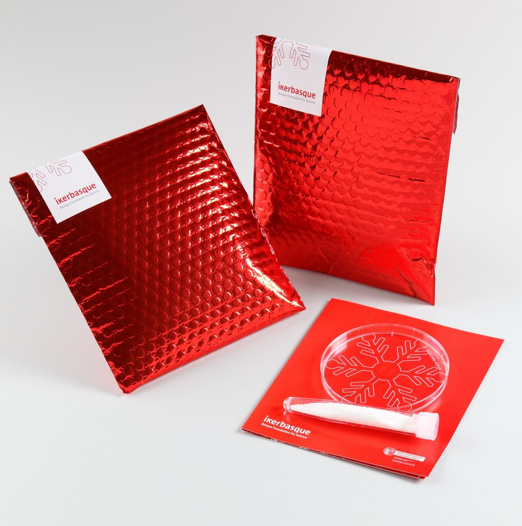 Diseño gráfico sobre rojo felicitación navidad probeta nieve artificial packaging Dt creativos